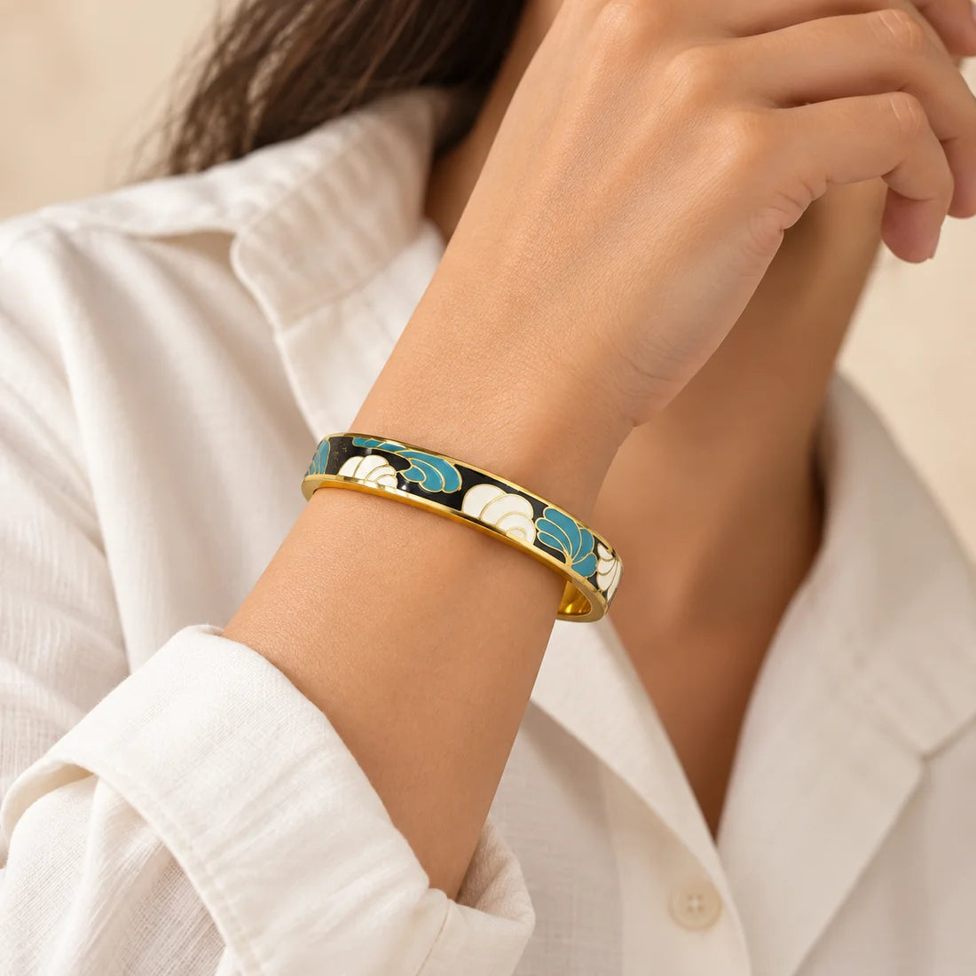 Midnight Petals stainless steel bangle in black, white with a floral design, worn on a model wrist