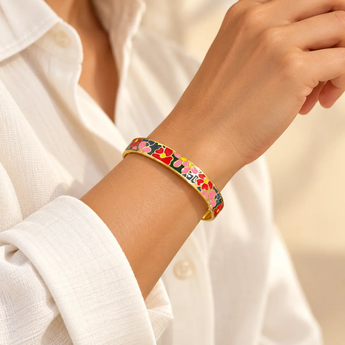 Fiesta Bloom stainless steel bangle in multicolour with a floral design, worn on a model wrist