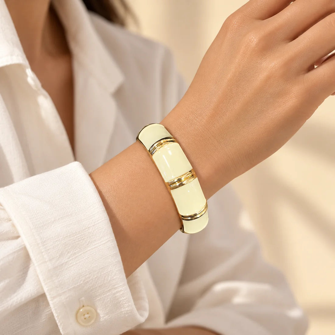 Vanilla Bands stainless steel bangle in ivory with a bands design, worn on a model wrist