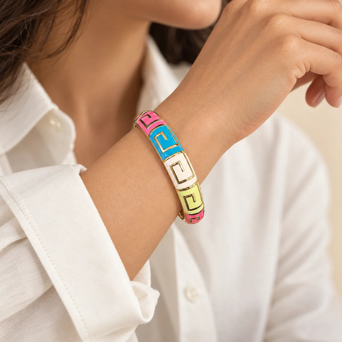 Candy Maze stainless steel bangle in pink, blue, green with a geometric design, worn on a model wrist