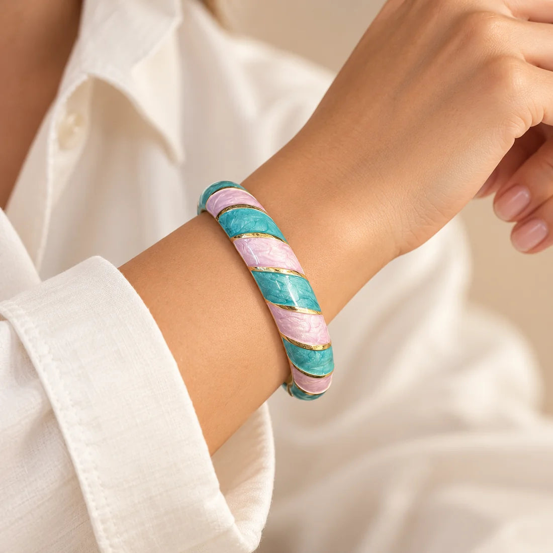 Lagoon Lilac stainless steel bangle in turquoise, purple with a diagonal stripe design, worn on a model wrist