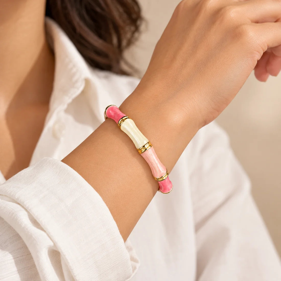 Blush Bamboo stainless steel bangle in pink, white with a colour block design, worn on a model wrist