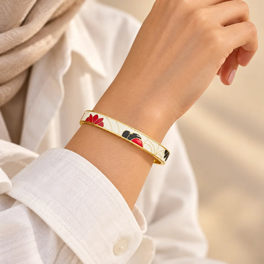 Crimson Bloom stainless steel bangle in white, red with a floral design, worn on a model wrist