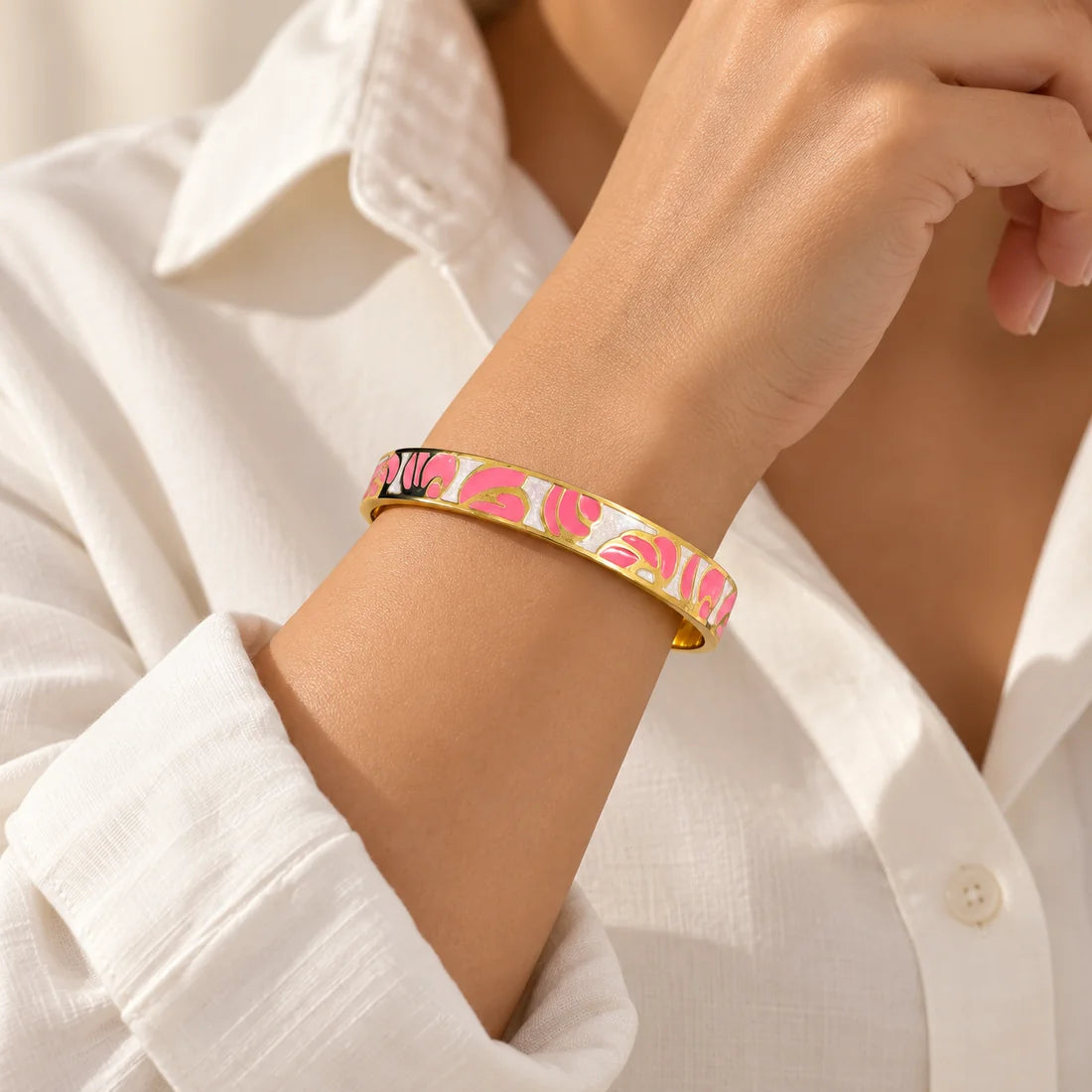 Rose Petals stainless steel bangle in pink, white with a floral design, worn on a model wrist