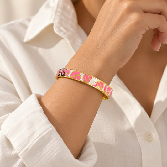 Rose Petals stainless steel bangle in pink, white with a floral design, worn on a model wrist