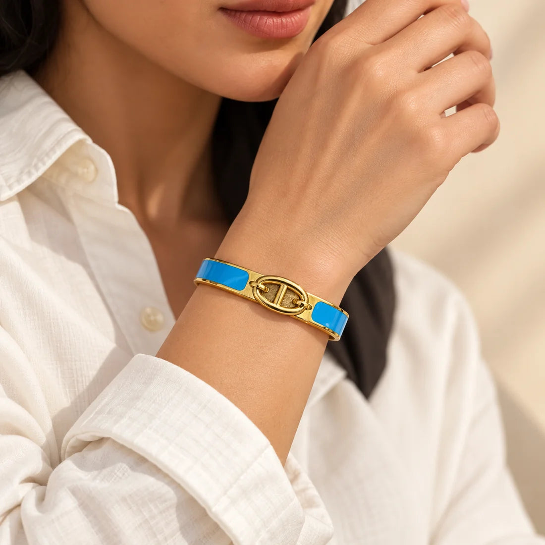 Azure Link stainless steel bangle in blue with a link motif design, worn on a model wrist