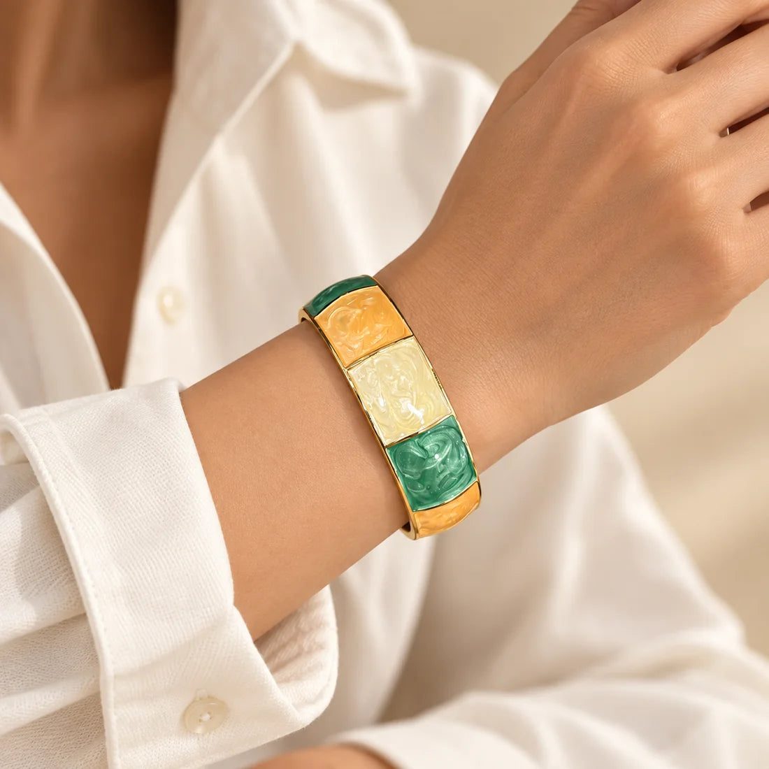 Citrus Jade stainless steel bangle in yellow, green, white with a colour block design, worn on a model wrist