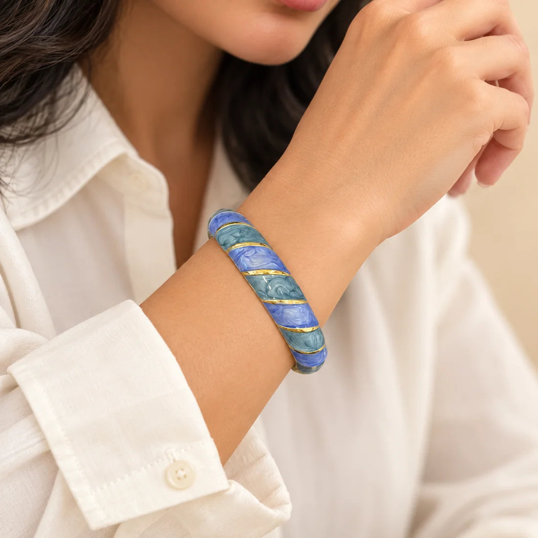 Blue Tide stainless steel bangle in blue with a diagonal stripe design, worn on a model wrist