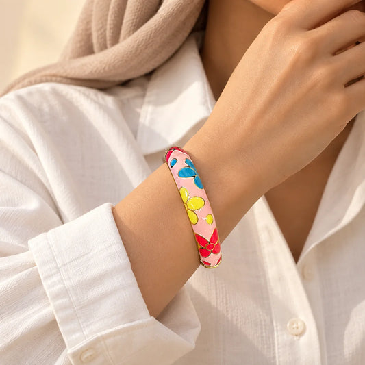 Candy Garden stainless steel bangle in pink, blue, yellow, red with a floral design, worn on a model wrist