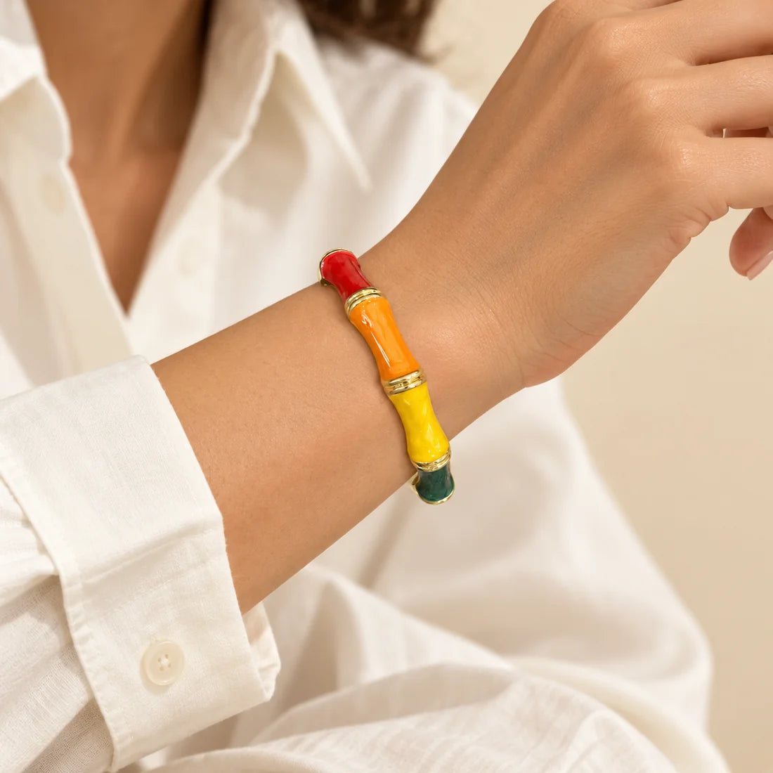 Tropical Bamboo stainless steel bangle in red, orange, yellow with a colour block design, worn on a model wrist