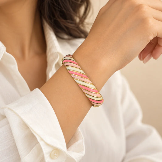 Sorbet Ribbons stainless steel bangle in pink, green, white with a diagonal stripe design, worn on a model wrist