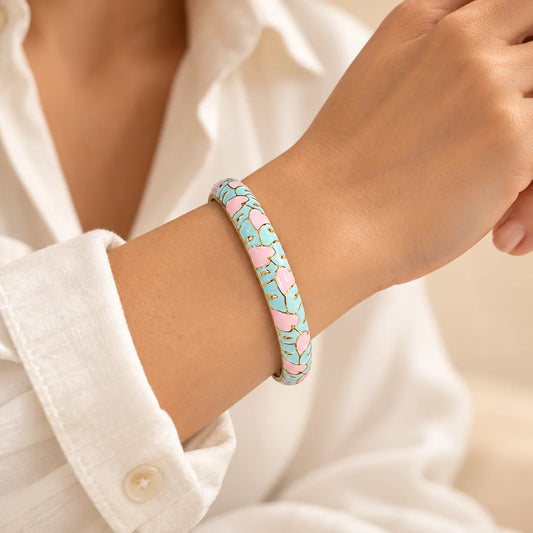 Aqua Petals stainless steel bangle in mint, pink, white with a floral design, worn on a model wrist