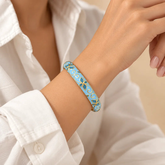Azure Floral Scroll stainless steel bangle in blue, white with a floral scroll design, worn on a model wrist