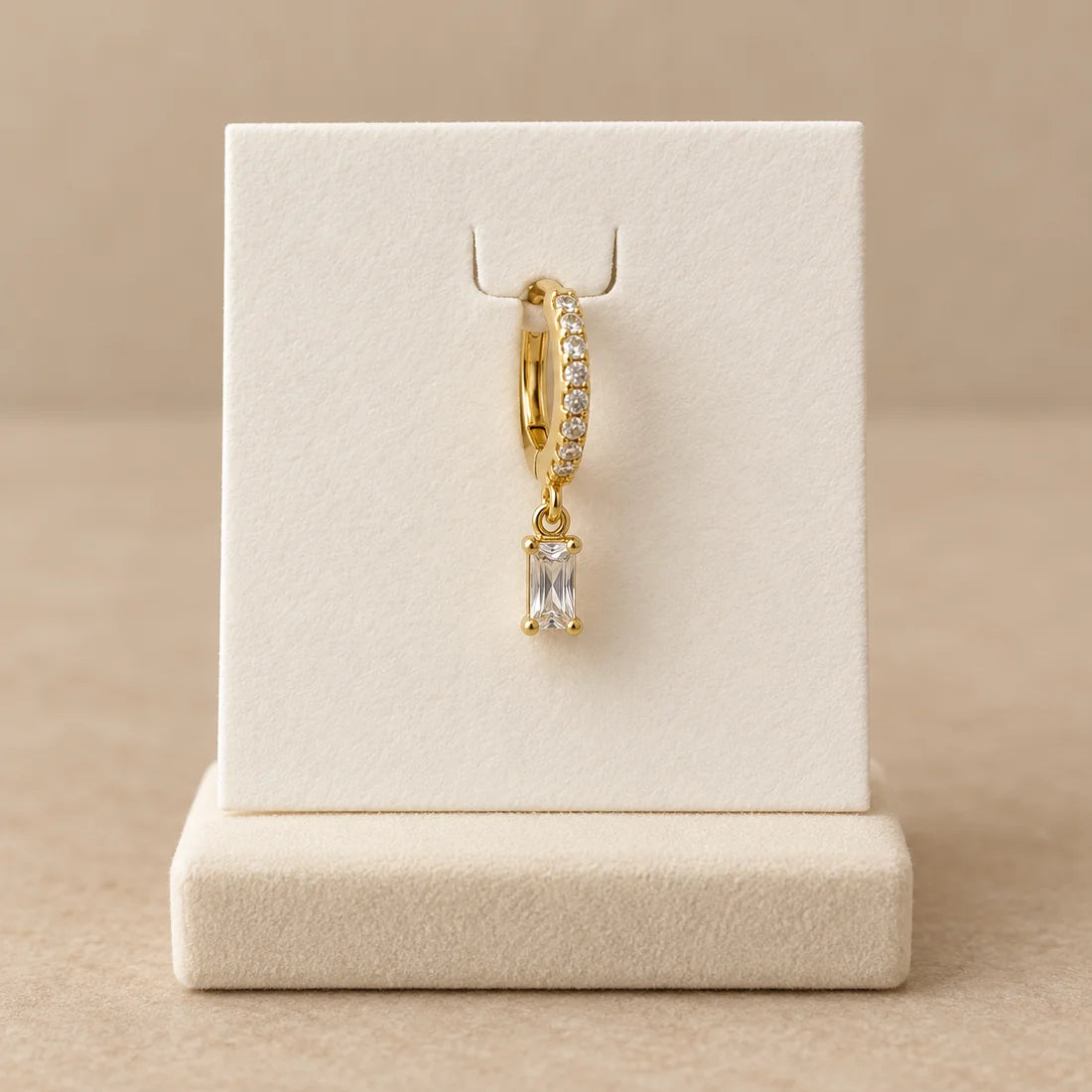 Baguette Drop Piercing displayed on an ivory jewelry card