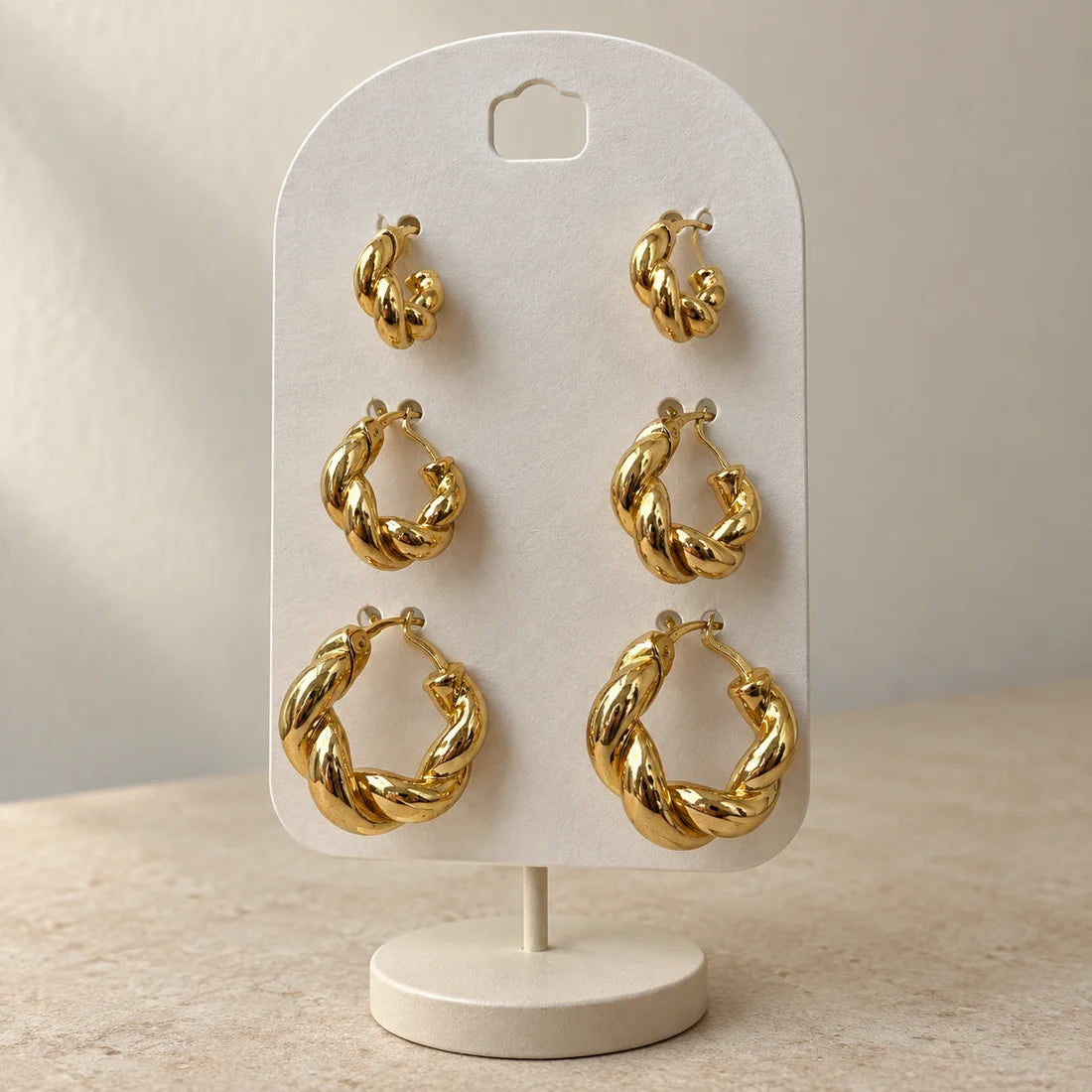 Golden Twist Hoops Set displayed on an ivory jewelry card