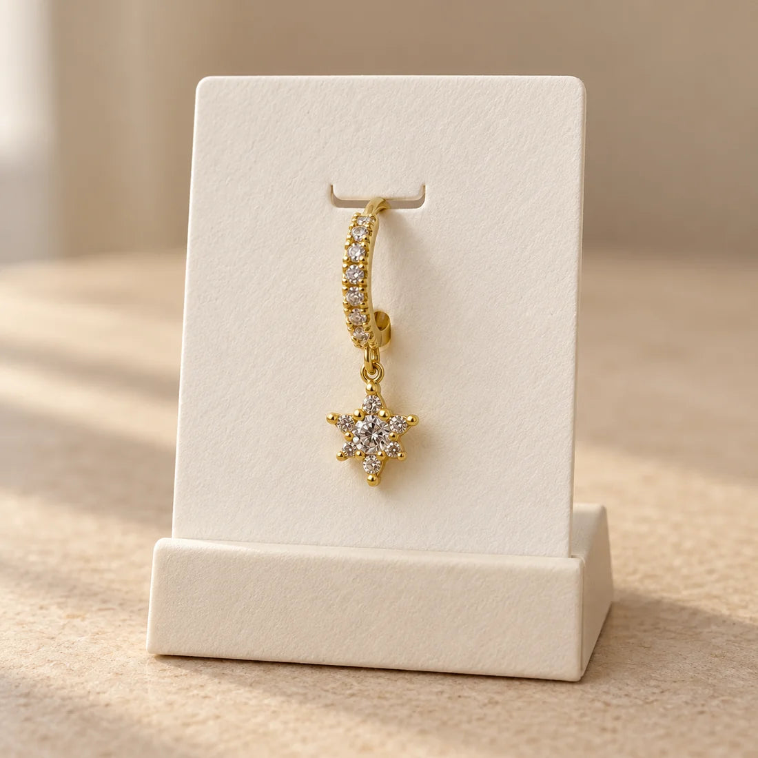 Starburst Hoop Piercing displayed on an ivory jewelry card